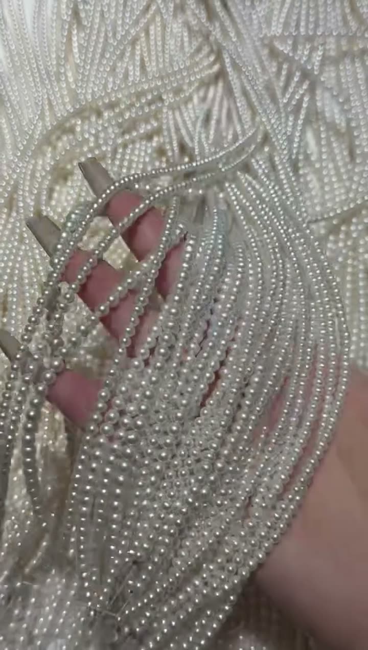 Pearl strands being checked by hand before buyer update